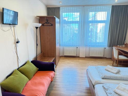 a living room with a couch and a television at Pension Sonnenschein in Halle an der Saale