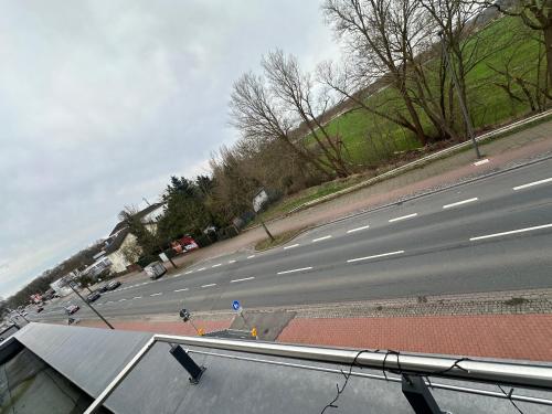 una calle vacía con coches aparcados a un lado de la carretera en Apartments & Pension Bremen Burglesum, en Bremen