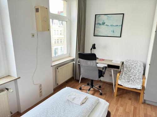 a room with a bed and a desk and a chair at Pension Sonnenschein in Halle an der Saale