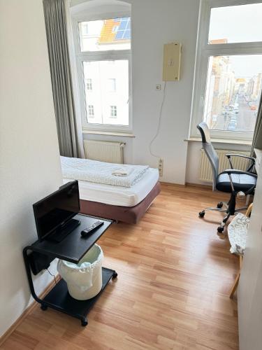 a room with a bed and a desk and a chair at Pension Sonnenschein in Halle an der Saale