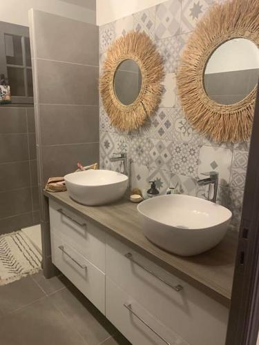 La salle de bains est pourvue de 2 lavabos et de miroirs sur un comptoir. dans l'établissement Superbe villa piscine Climatisation, à Six-Fours-les-Plages