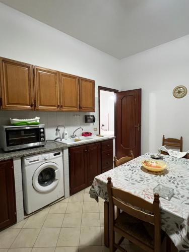 una cucina con tavolo, lavandino e lavastoviglie di Da Maria a Terrasini