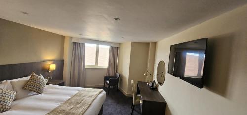 a hotel room with a bed and a desk and a television at Park Hall Hotel,Chorley,Preston in Eccleston