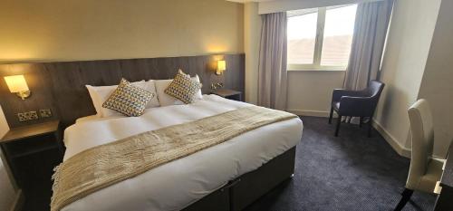 a hotel room with a large bed and a window at Park hall Hotel & Spa Lancashire, a member of Radisson Individuals in Eccleston