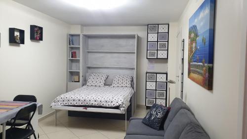 mały pokój z łóżkiem i kanapą w obiekcie Cocooning w Mentonie