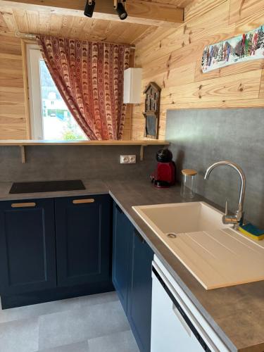 une cuisine avec des armoires bleues et un évier dans l'établissement L'OURSIERE à Saint MAMET, à Saint-Mamet