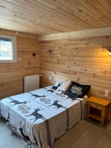 une chambre avec un lit dans une cabane en bois dans l'établissement L'OURSIERE à Saint MAMET, à Saint-Mamet