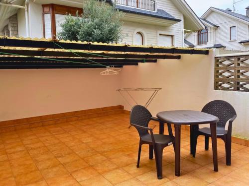 un patio con tavolo e sedie su un piano di Apartamentos Melgarden - Campo del Marqués a Santoña