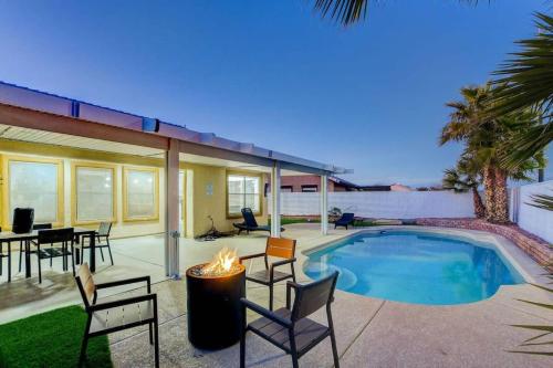 un patio trasero con piscina y fogata en Chic 4BR Home w Pool, Jacuzzi, Billiards & Firepit, en Las Vegas