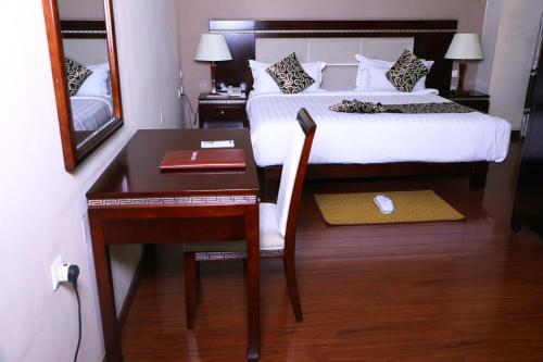 a bedroom with a desk and a bed and a desk at Melka International Hotel in Addis Ababa