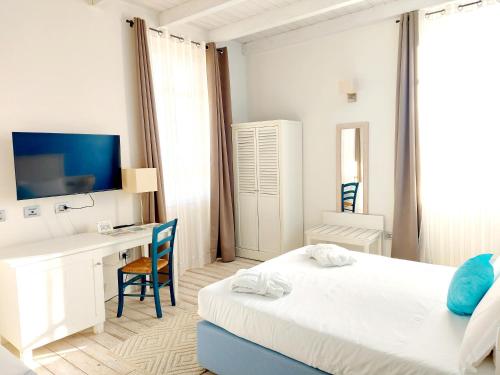 a white bedroom with a desk and a bed at Hotel La Villa Del Mare in Cagliari