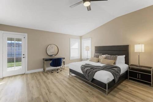 1 dormitorio con cama, escritorio y ventana en Chic 4BR Home w Pool, Jacuzzi, Billiards & Firepit, en Las Vegas