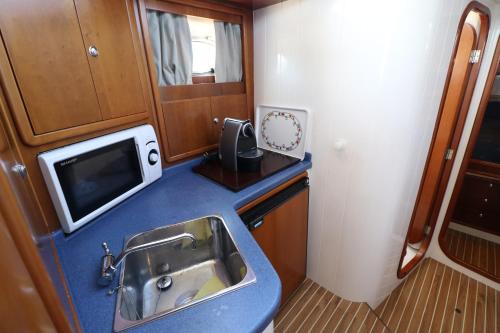 a small kitchen with a sink and a microwave at Private yacht, we love our guests in Lisbon