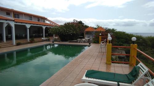 a swimming pool in front of a building at Por de Sol - Aux repos des skippers in Cidade Velha