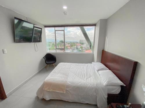 sypialnia z łóżkiem i dużym oknem w obiekcie Gran suite en Samborondonķo w mieście SamborondÃ³n