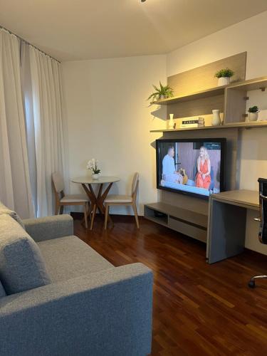 uma sala de estar com um sofá e uma televisão de ecrã plano em Flat Premium -Acesso a pé ao shopping Center vale - Edifício Summit (Ar condicionado) em São José dos Campos