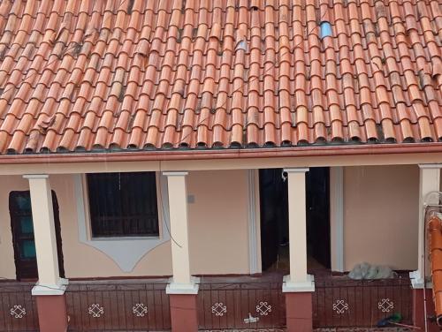 um edifício com um telhado de azulejo vermelho com uma janela em Hermoso Apartamento rustico en el centro em Cochabamba