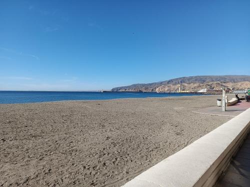 una playa de arena junto a un cuerpo de agua en Veguita 2: piso renovado a 3 min de la playa, en Almería