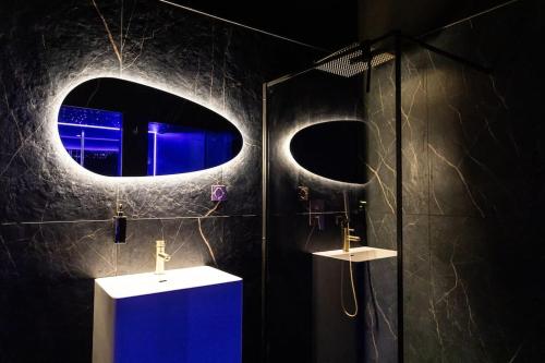 a bathroom with a shower with a blue cabinet and a mirror at Loveroom Ô Diable Des Plaisirs avec jacuzzi in Tourcoing