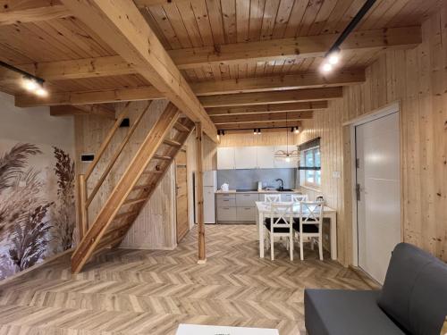 a kitchen and dining room with a staircase in a tiny house at Domki Polskie Morze in Pobierowo