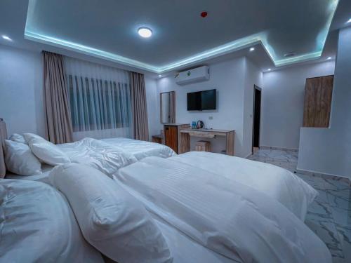Habitación de hotel con 2 camas y almohadas blancas en Petra Caravan Guest House, en Wadi Musa