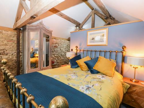 1 dormitorio con 1 cama con sábanas azules y amarillas en The Old Cow House en Bridgnorth