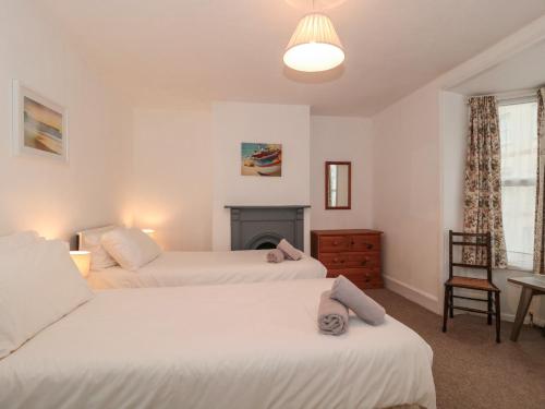 um quarto com 2 camas e uma lareira em Howard Cottage em Weymouth