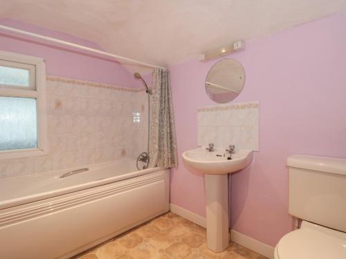 uma casa de banho com um lavatório, uma banheira e um WC. em Howard Cottage em Weymouth