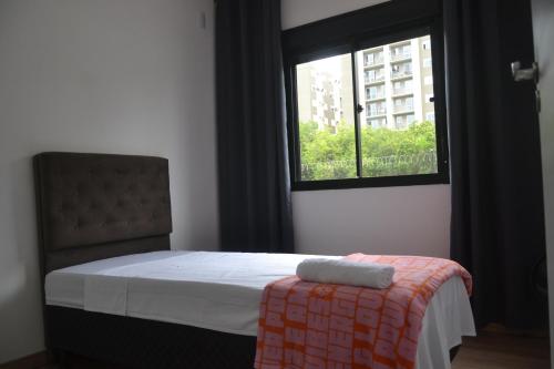 1 dormitorio con cama y ventana en Refúgio em Pelotas Com NF-E en Pelotas