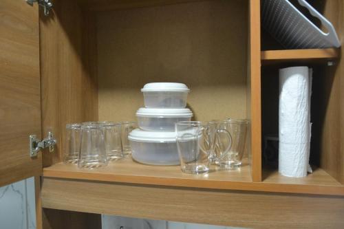 a wooden cabinet with glasses on a shelf at Refúgio em Pelotas Com NF-E in Pelotas