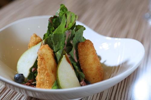 a white bowl of food with apples and greens at InterContinental Real Santo Domingo by IHG in Santo Domingo