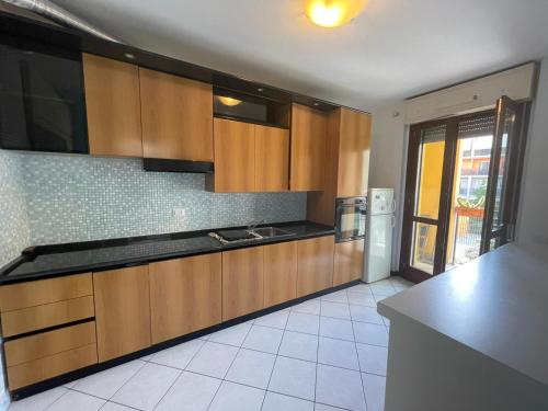 a kitchen with wooden cabinets and a counter top at Camere Rozzano, vicino Humanitas in Rozzano