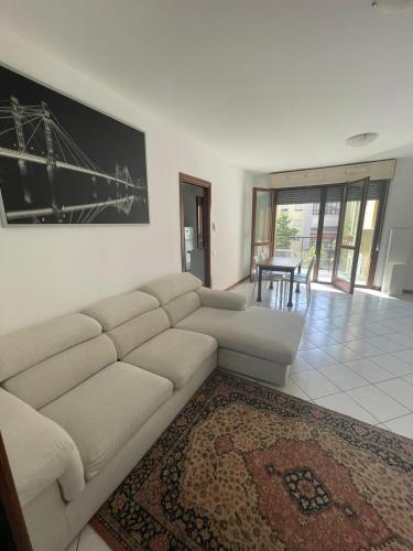 Camere Rozzano, vicino Humanitas في روتسانو: غرفة معيشة مع أريكة بيضاء وسجادة