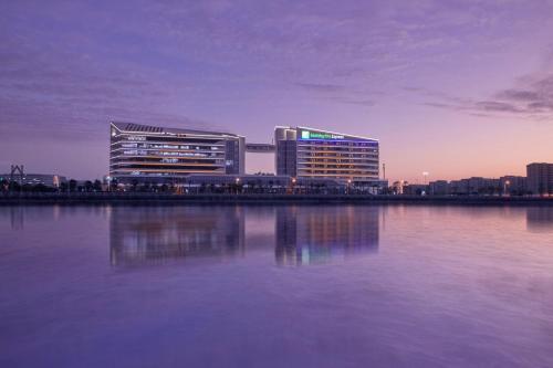two tall buildings next to a body of water at Holiday Inn Express Xiamen Airport Zone by IHG in Xiamen
