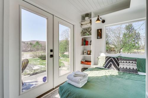1 dormitorio con ventana y 1 cama con toallas en Zen Box Tranquil Vermont Escape with Lake Views!, en Castleton