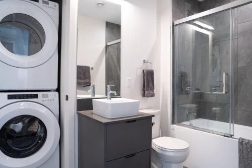 y baño con lavadora y lavamanos. en Snowed Inn - Stunning 3 Bedroom Condo, en Revelstoke