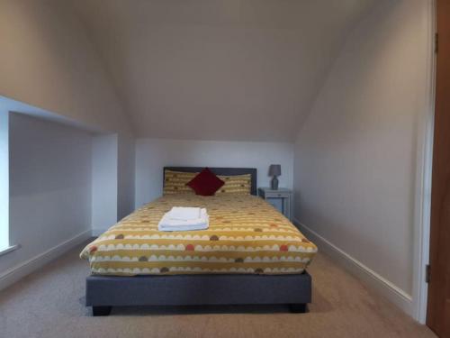 1 dormitorio con 1 cama con manta amarilla en No.12 - The Meadow, en Banbury