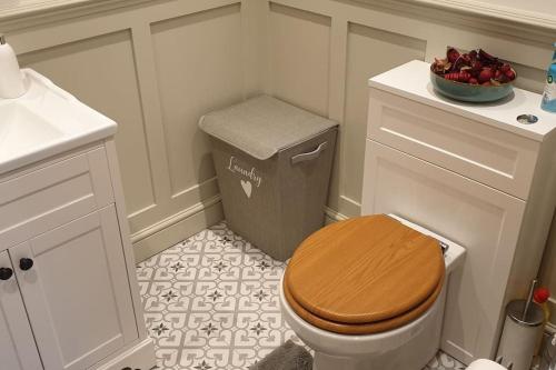 a bathroom with a wooden toilet and a sink at No.12 - The Meadow in Banbury