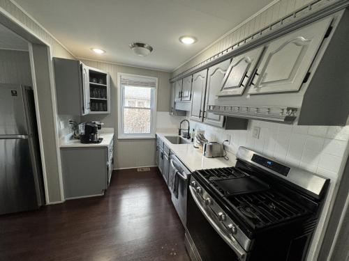 a kitchen with white cabinets and a stove top oven at Spacious Retreat Near Convention Centers home in Des Plaines