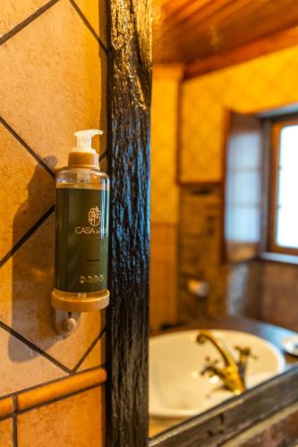 a soap dispenser on a wall next to a sink at Casa da Vila - Manteigas in Manteigas