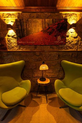 a room with two chairs and a table with a lamp at Casa da Vila - Manteigas in Manteigas
