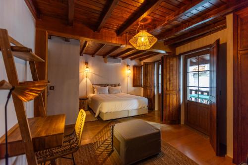 a bedroom with a bed and a table and a chair at Casa da Vila - Manteigas in Manteigas