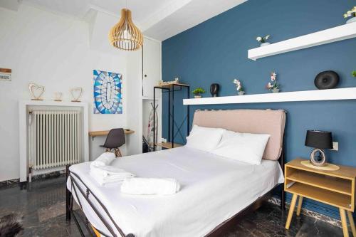 um quarto com uma cama grande e uma parede azul em Splendid view of Acropolis em Atenas