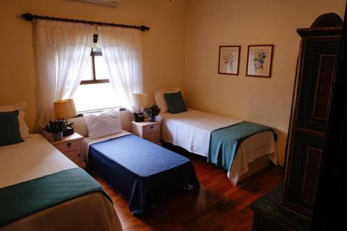een slaapkamer met 2 bedden en een raam bij Linda casa 1h30 de SP dentro de HARAS com LAZER in Boituva
