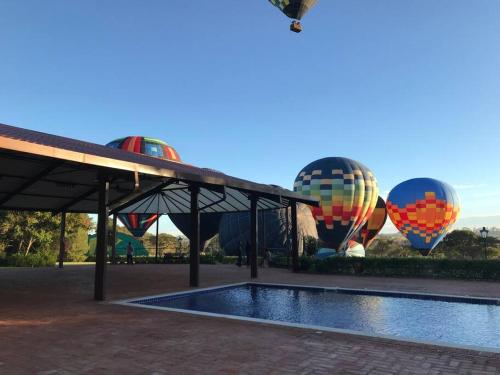 een groep heteluchtballonnen naast een zwembad bij Linda casa 1h30 de SP dentro de HARAS com LAZER in Boituva