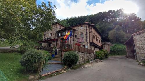 un edificio con una bandera en la parte delantera en Hotel Casona de la Torre, en Ruente