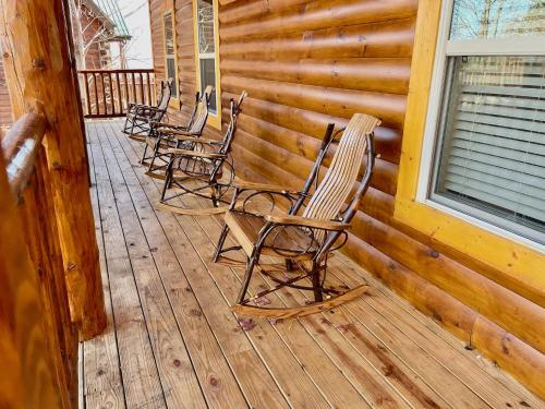 a row of chairs sitting on a porch at New Luxe Cabin-Great Views, Pool, Hot Tub, Theater in Sevierville