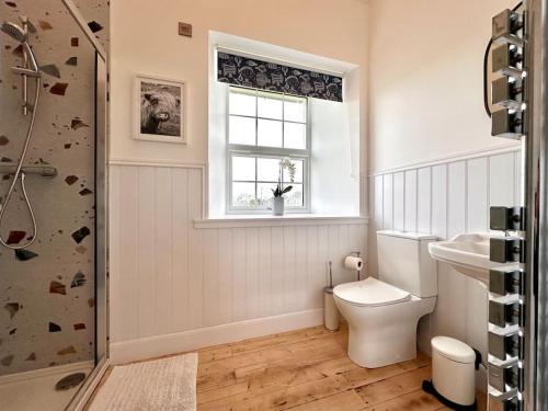 a bathroom with a toilet and a sink and a window at Modern Refurbished Church nr Butt of Lewis beaches in Port of Ness