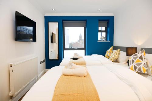 Habitación con una gran cama blanca y paredes azules. en London City Self Check-in Luxury Rooms en Londres