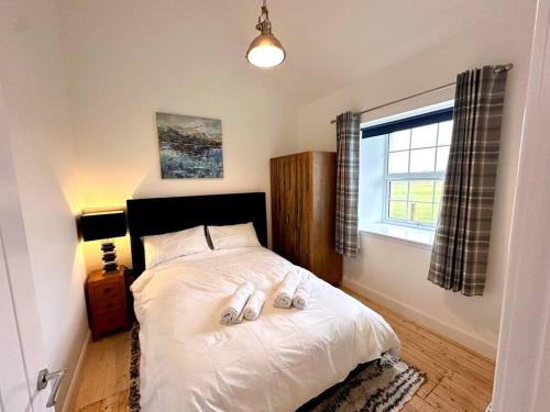 a bedroom with a bed with two towels on it at Modern Refurbished Church nr Butt of Lewis beaches in Port of Ness